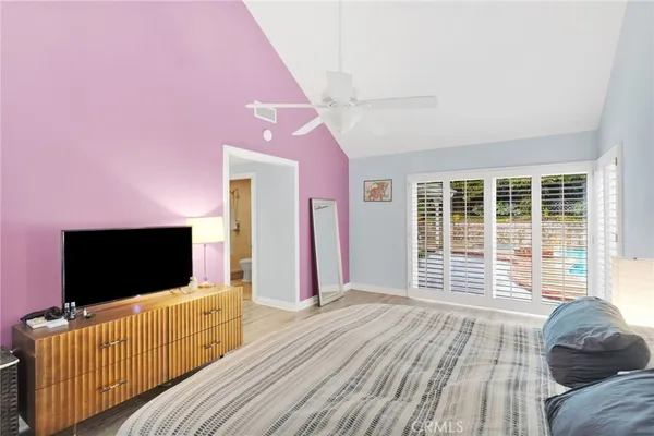 a view of a hallway with wooden floor and a bathroom