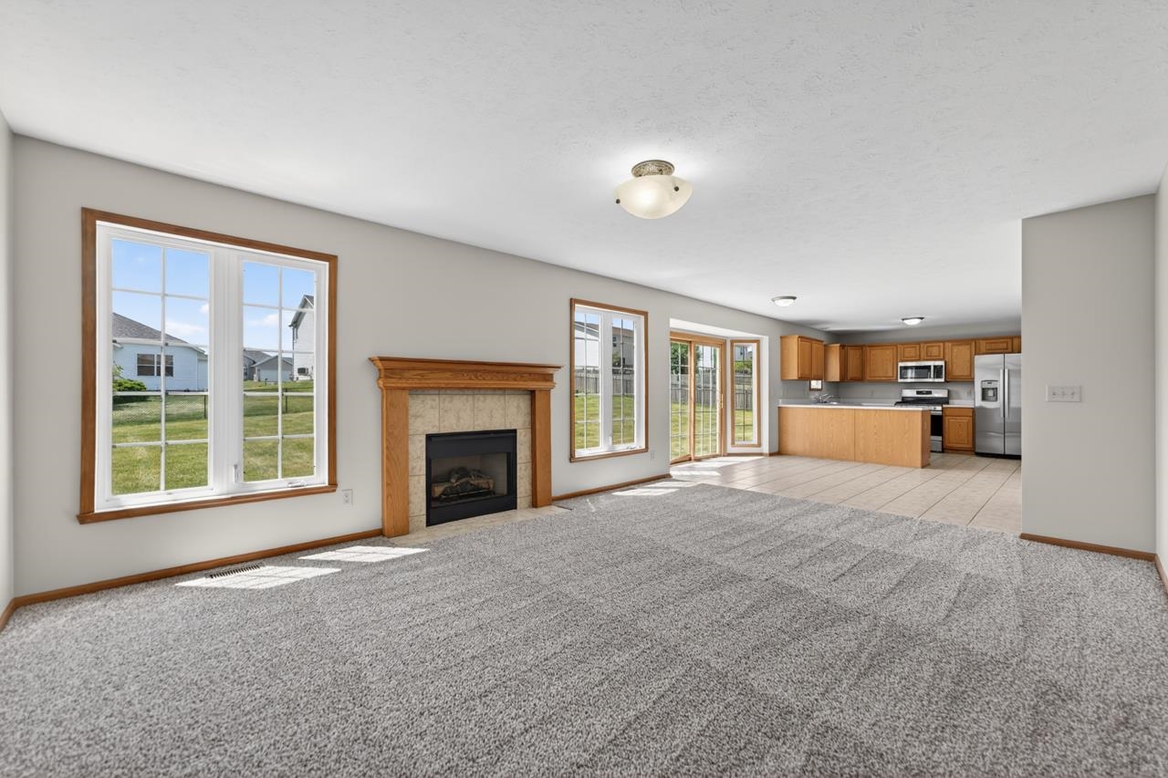 676 Elberon Way Roscoe, IL 61073 - Photo 9 of 30 a view of an empty room with a fireplace and a window