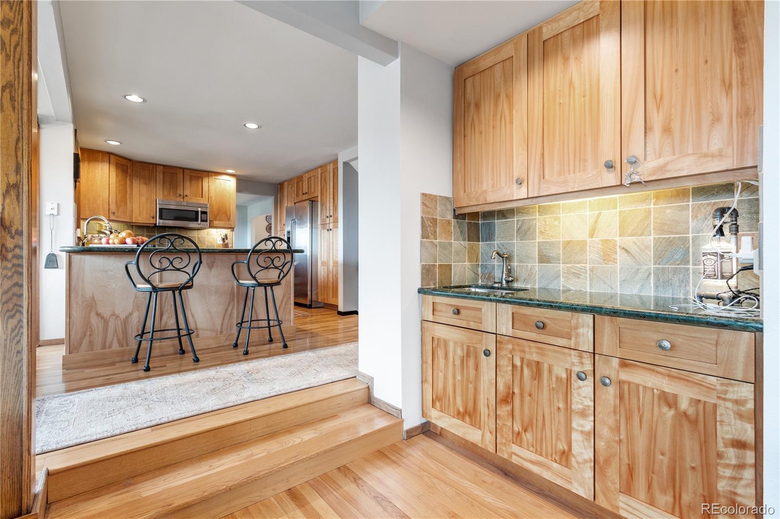 6674 Fairways Drive Longmont, CO 80503 - Photo 15 of 40 a view of a kitchen with granite countertop a refrigerator oven cabinets a sink and a counter top space