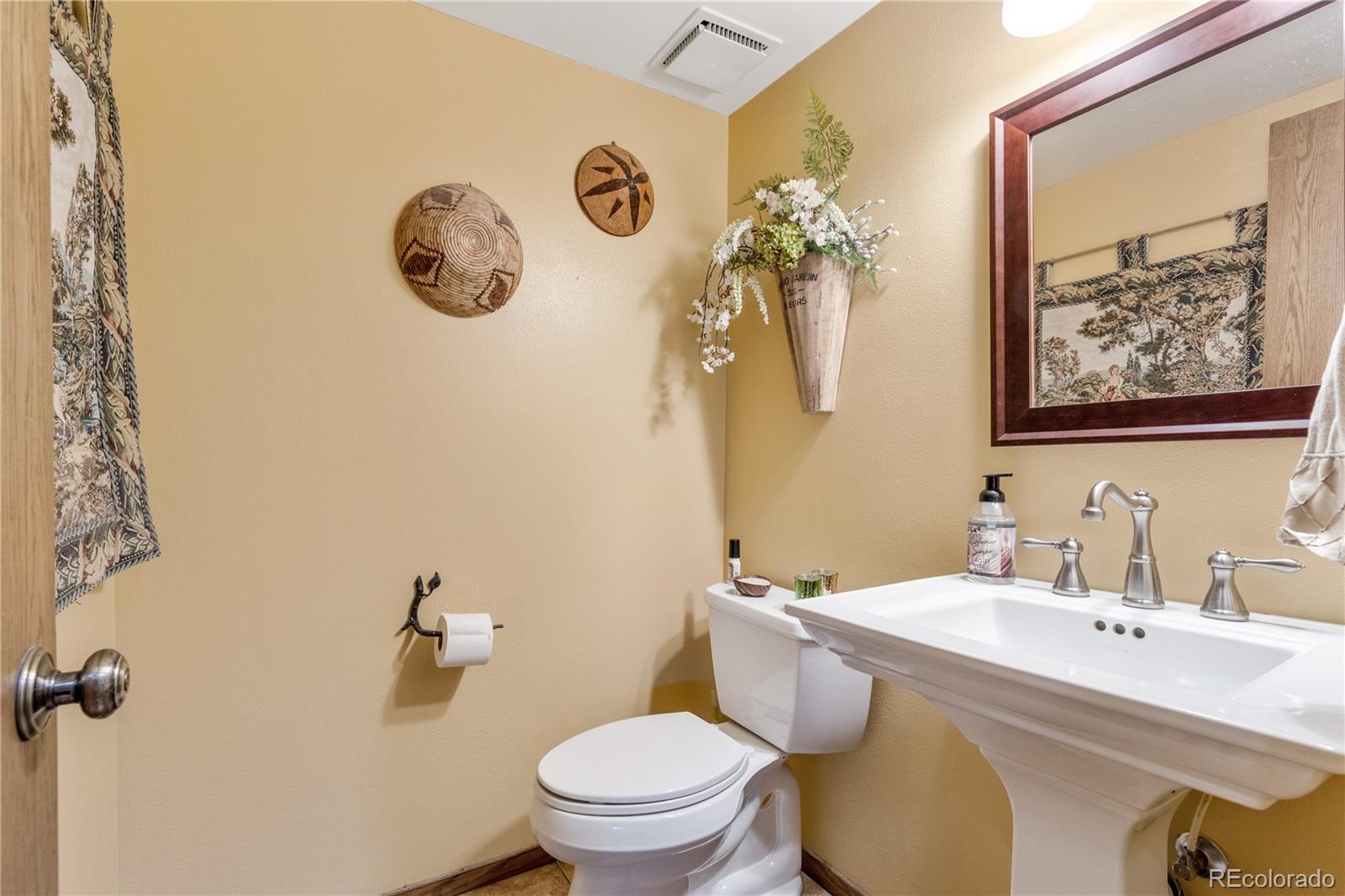 6674 Fairways Drive Longmont, CO 80503 - Photo 16 of 40 a bathroom with a toilet sink and mirror
