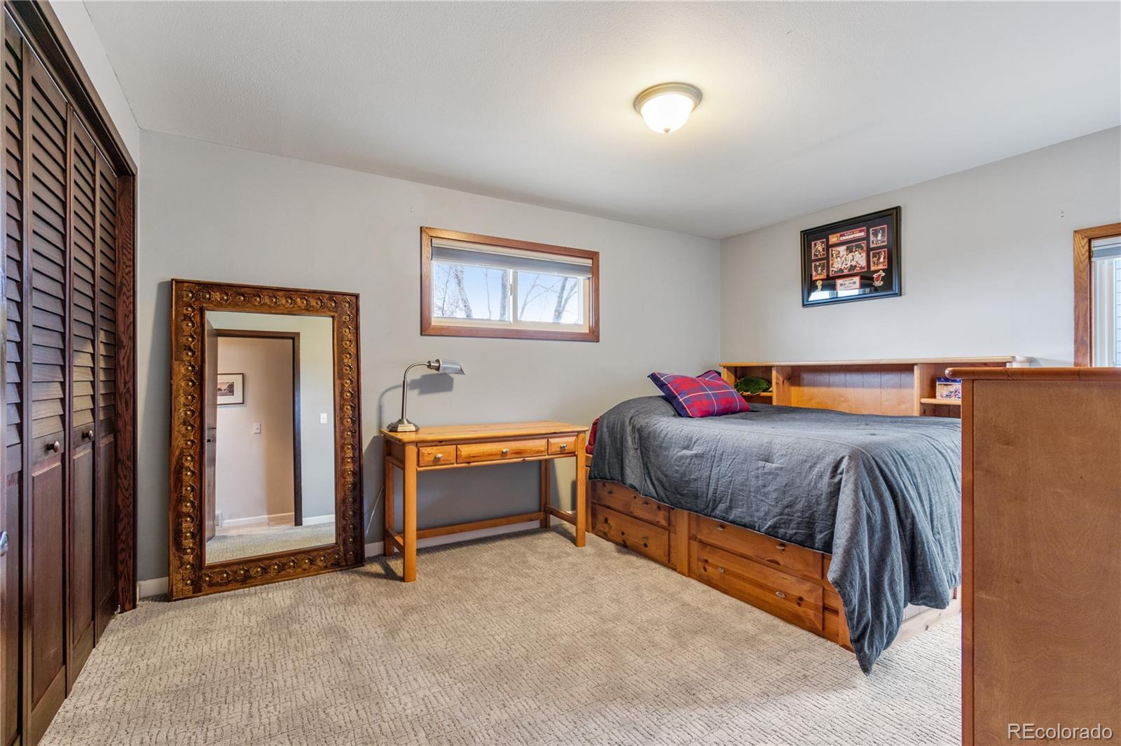 6674 Fairways Drive Longmont, CO 80503 - Photo 22 of 40 a spacious bedroom with a bed and a table