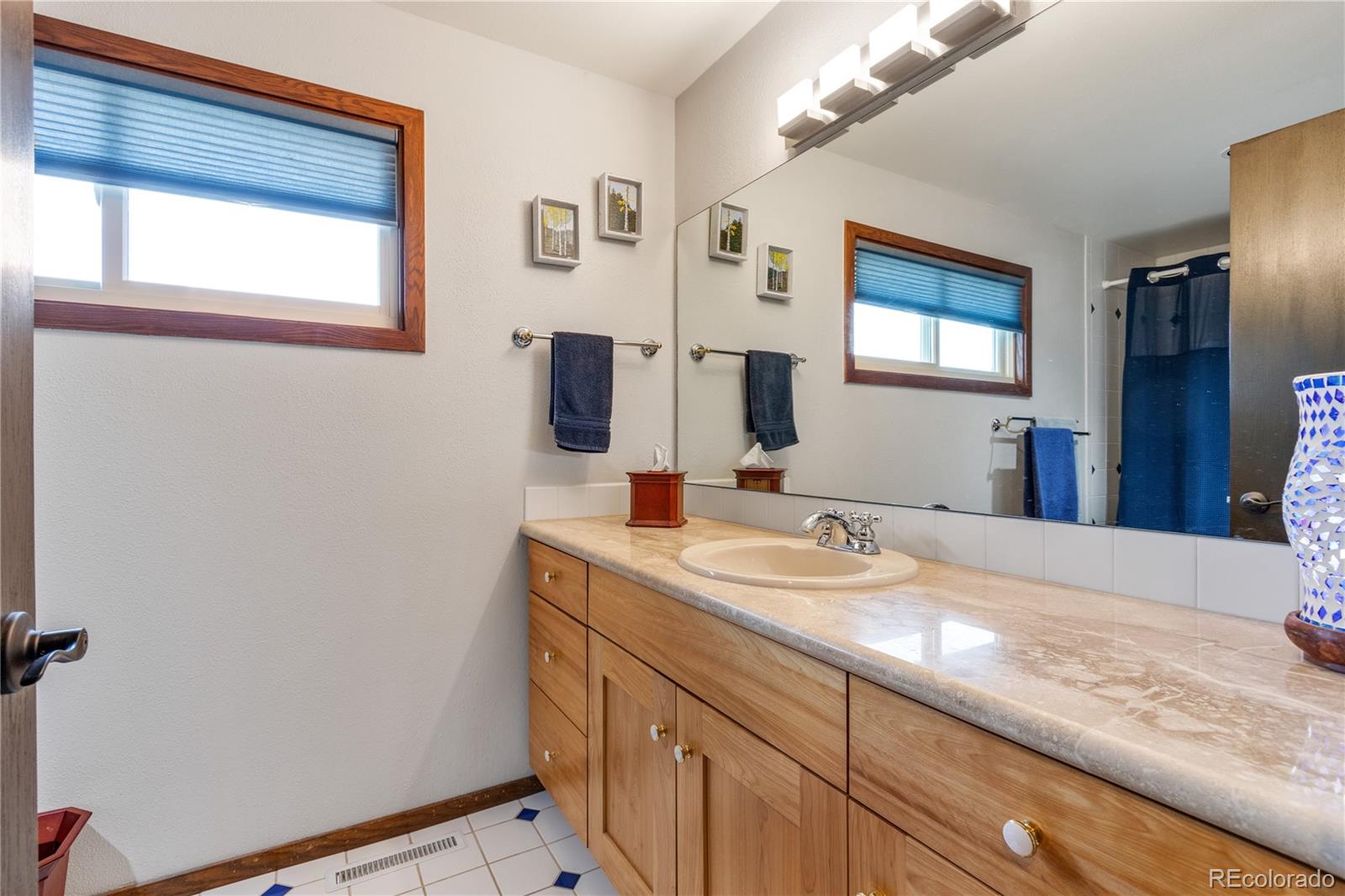 6674 Fairways Drive Longmont, CO 80503 - Photo 24 of 40 a bathroom with a sink a vanity and a mirror