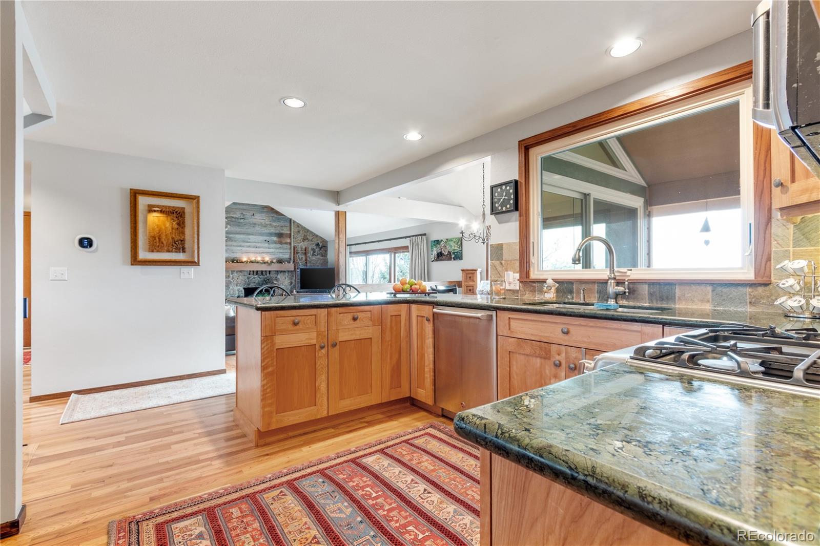 6674 Fairways Drive Longmont, CO 80503 - Photo 9 of 40 a kitchen with stainless steel appliances granite countertop a sink and cabinets
