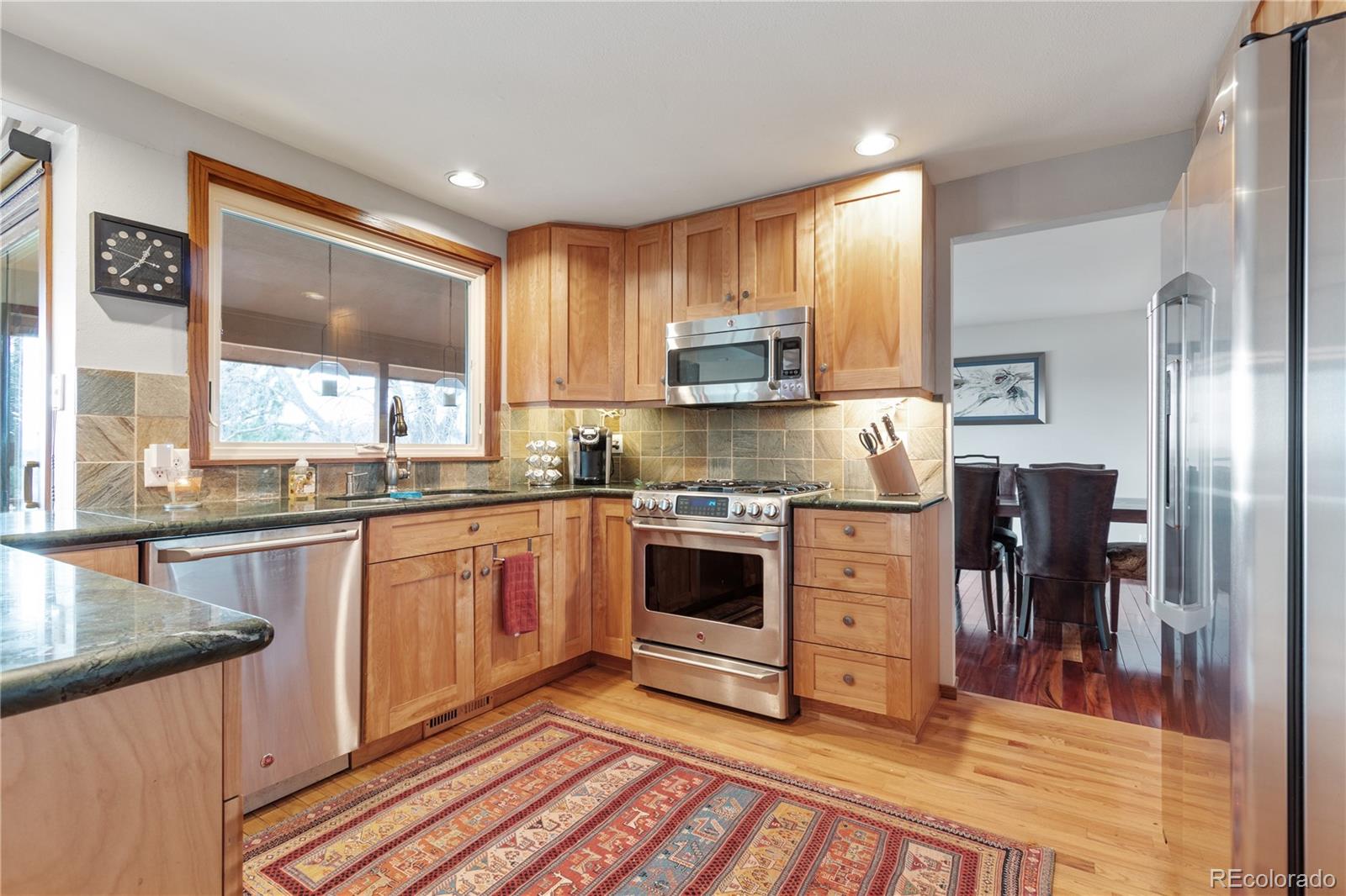 6674 Fairways Drive Longmont, CO 80503 - Photo 10 of 40 a kitchen with kitchen island granite countertop a stove top oven a sink a counter top space and cabinets