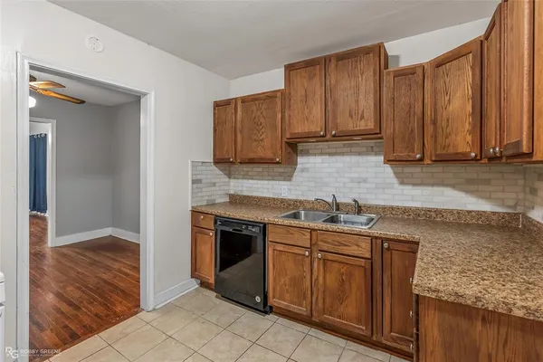 a kitchen with granite countertop a sink stove and cabinets