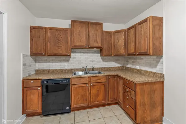 a kitchen with granite countertop stainless steel appliances a sink window and cabinets