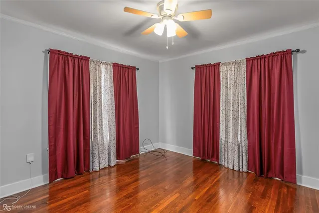 a view of a bedroom with wooden floor and red walls