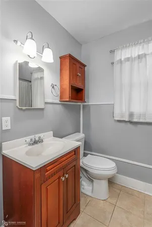 a bathroom with a sink a toilet and mirror