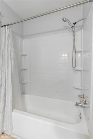 a bathroom with a shower and a bath tub
