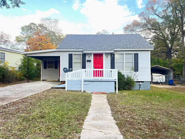 a front view of a house with yard patio and green space