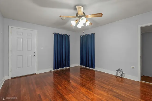 a view of an empty room with wooden floor