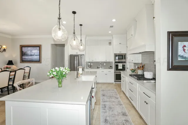 a kitchen with granite countertop a white cabinets and appliances