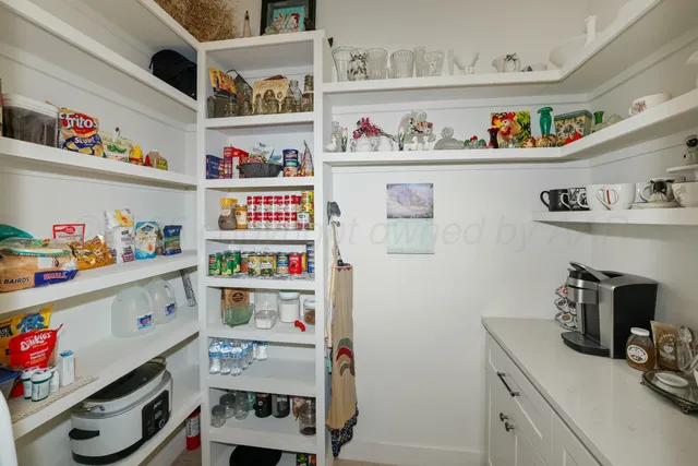 a utility room with lots of clutter and cabinets