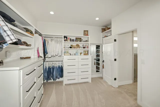 a view of walk in closet with clothes and shoes