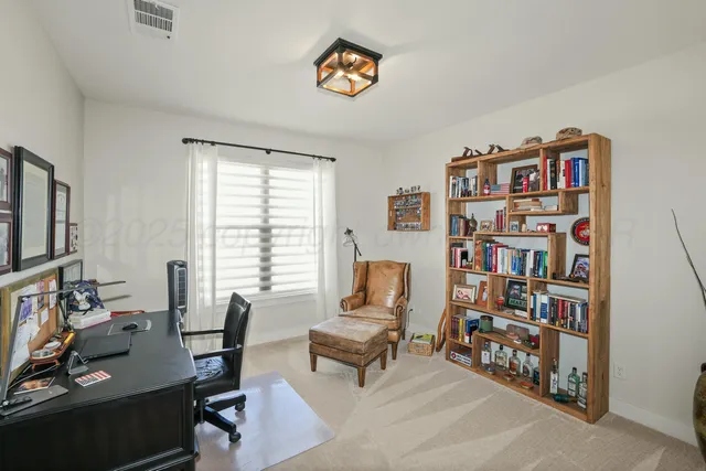 a living room with furniture a bookshelf and a window