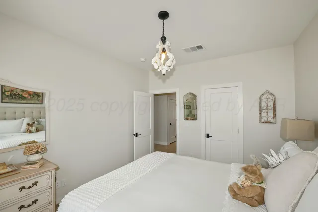 a bedroom with a bed and a chandelier