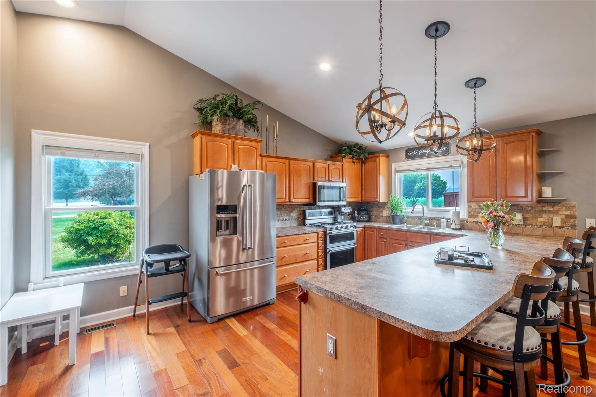 10250 Duffield Road Gaines, MI 48436 - Photo 20 of 28 Vaulted ceiling, wood-finish flooring, stainless steel appliances, breakfast bar island, and pendant lighting