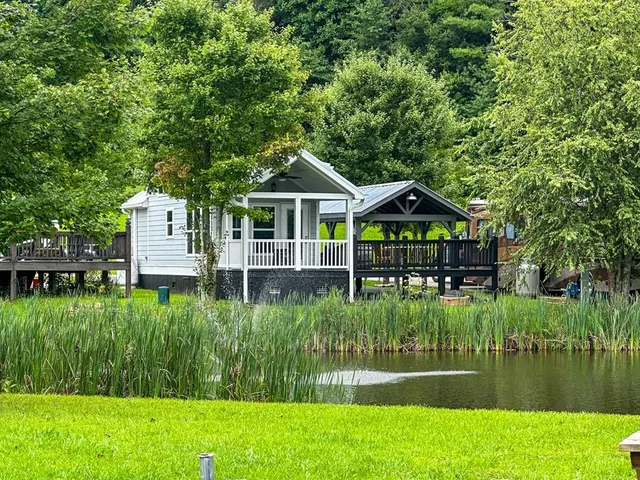 a front view of a house with a yard and lake view