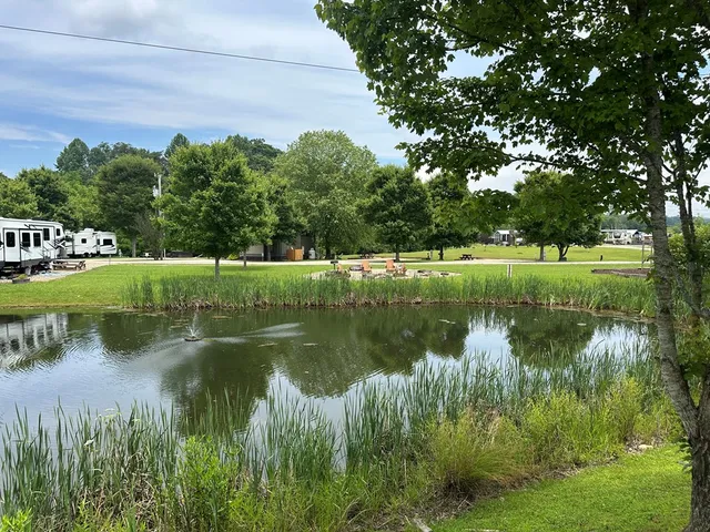 a view of a refrigerator in kitchen and an empty room with wooden floor