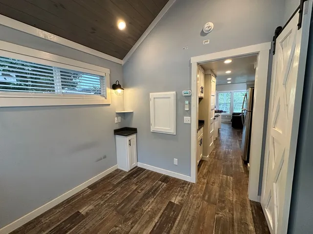 a view of a house with a large window and a yard with wooden fence