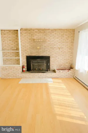 a view of an empty room with a fireplace and a window