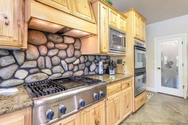 a kitchen with stainless steel appliances granite countertop a stove and a refrigerator