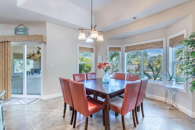 a dining room with furniture a chandelier and window