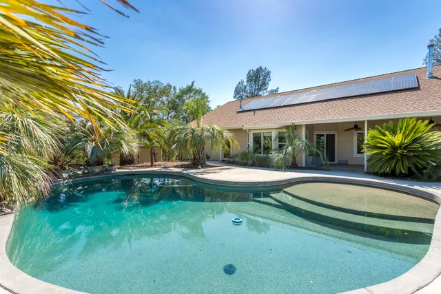 a view of a house with swimming pool and a yard