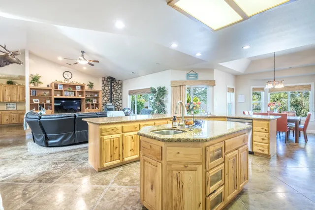 a kitchen with stainless steel appliances granite countertop a sink a stove and a refrigerator