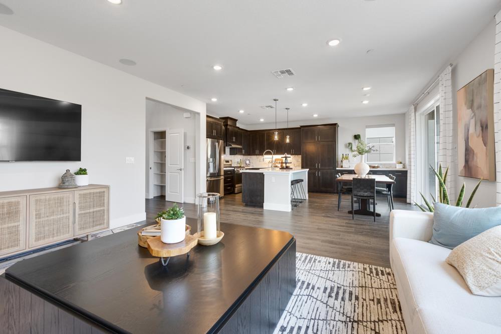 8435 Kyler Road Elk Grove, CA 95757 - Photo 11 of 56 a living room with stainless steel appliances kitchen island granite countertop a couch a dining table and chairs