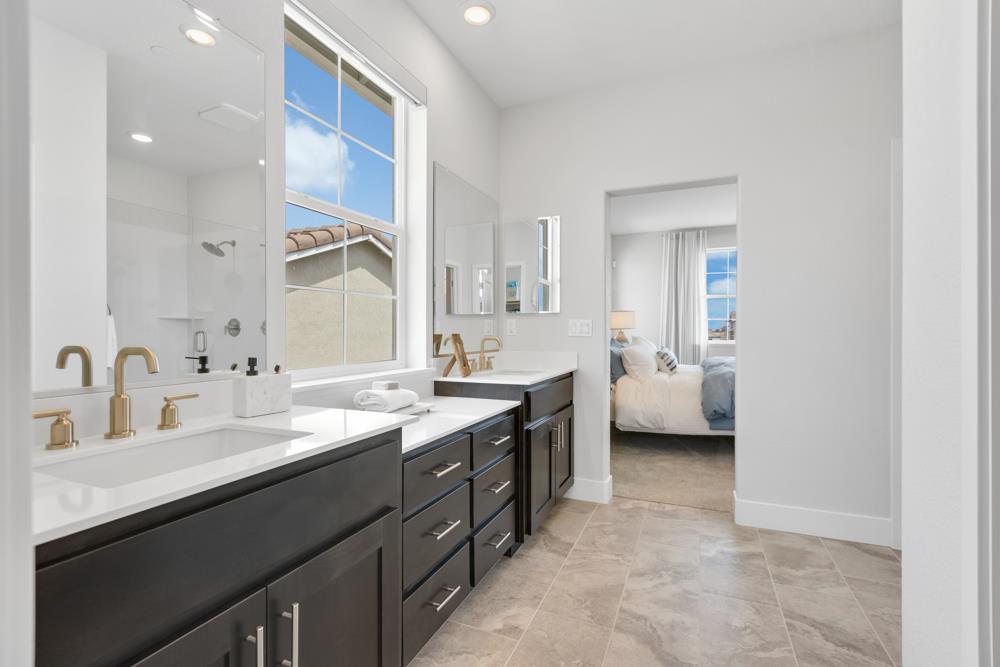 8435 Kyler Road Elk Grove, CA 95757 - Photo 16 of 56 a en suite bathroom with a double vanity sink a mirror and a