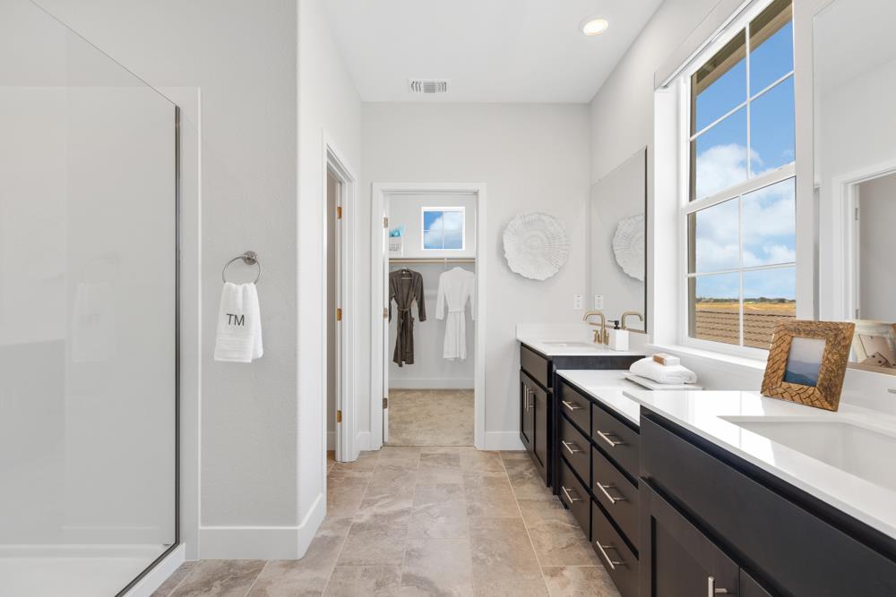 8435 Kyler Road Elk Grove, CA 95757 - Photo 17 of 56 a spacious bathroom with a granite countertop sink and a mirror