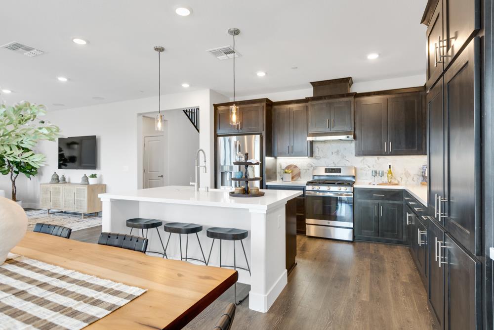 8435 Kyler Road Elk Grove, CA 95757 - Photo 3 of 56 a large kitchen with kitchen island a large center island and stainless steel appliances