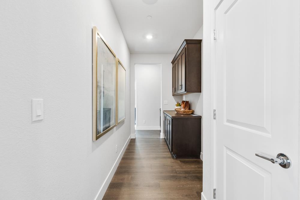 8435 Kyler Road Elk Grove, CA 95757 - Photo 46 of 56 a hallway with a couch and wooden floor