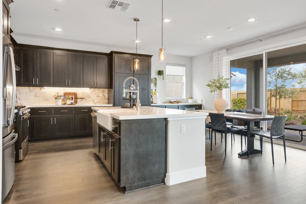 8435 Kyler Road Elk Grove, CA 95757 - Photo 5 of 56 a kitchen with a table chairs sink and cabinets