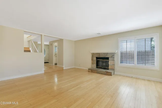 a view of an empty room with a fireplace and a window