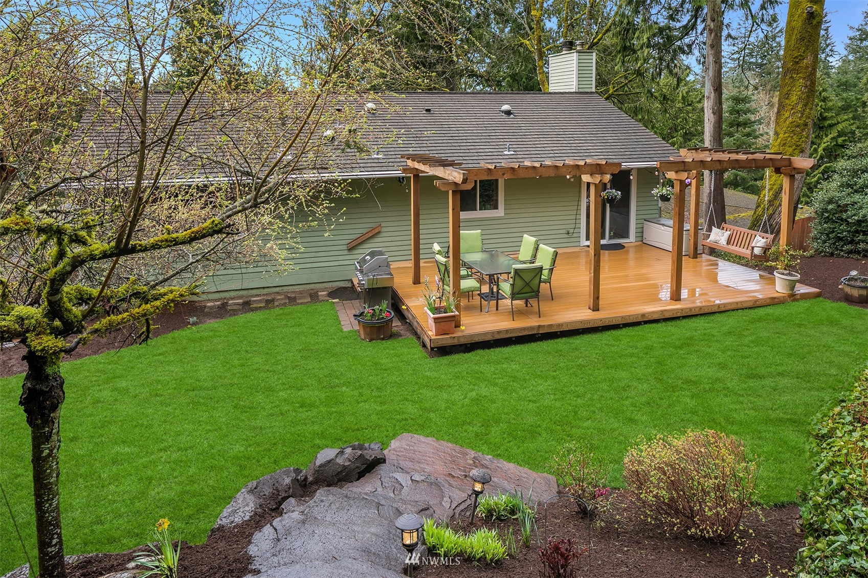 21832 Northeast 8th Street Sammamish, WA 98074 - Photo 33 of 40 a view of a backyard with table and chairs potted plants and large tree