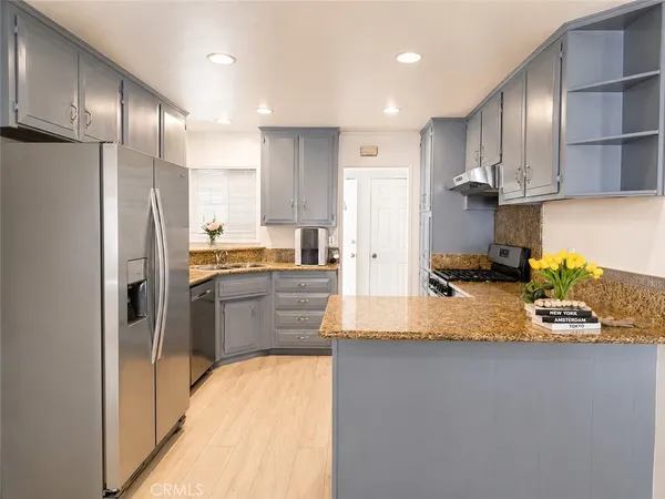 a kitchen with stainless steel appliances granite countertop a refrigerator and a stove