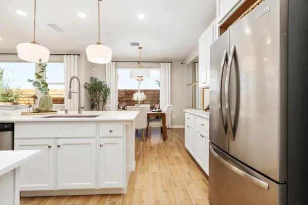 a kitchen with a dining table chairs sink and cabinets