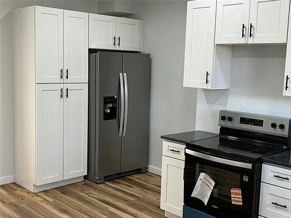 a kitchen with stainless steel appliances granite countertop a refrigerator and a stove top oven