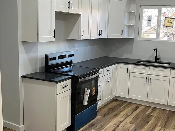 a kitchen with granite countertop white cabinets and white appliances