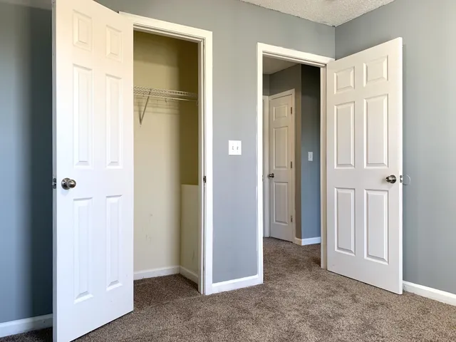an empty room with windows and closet