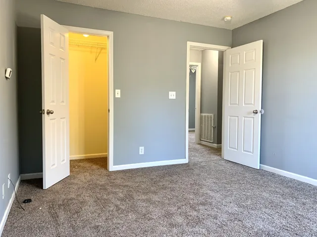 an empty room with closet and a bathroom