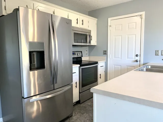 a kitchen with stainless steel appliances a refrigerator stove and sink