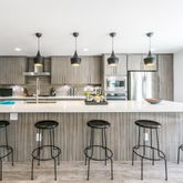 a kitchen with stainless steel appliances a sink a stove a refrigerator a center island and cabinets