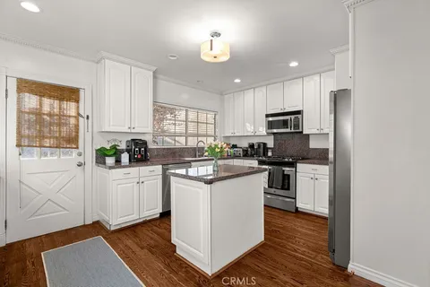 a kitchen with white cabinets and appliances