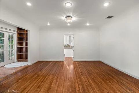 a view of empty room with wooden floor and window