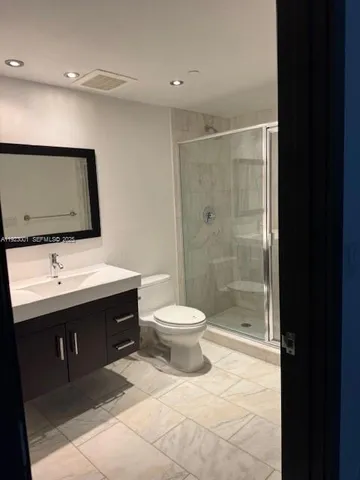 a bathroom with a toilet sink a mirror and shower