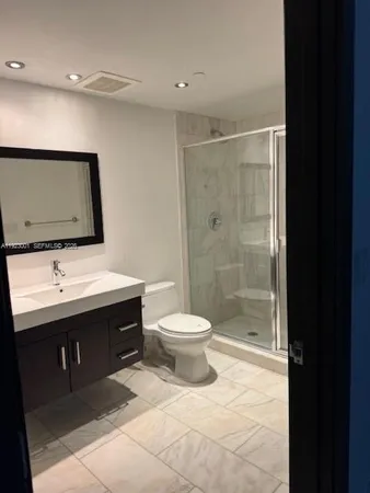 a bathroom with a toilet sink a mirror and shower