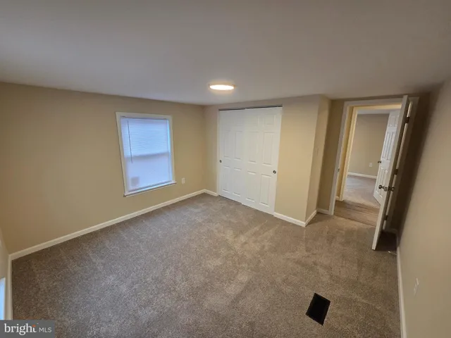 an empty room with windows and entrance to other room